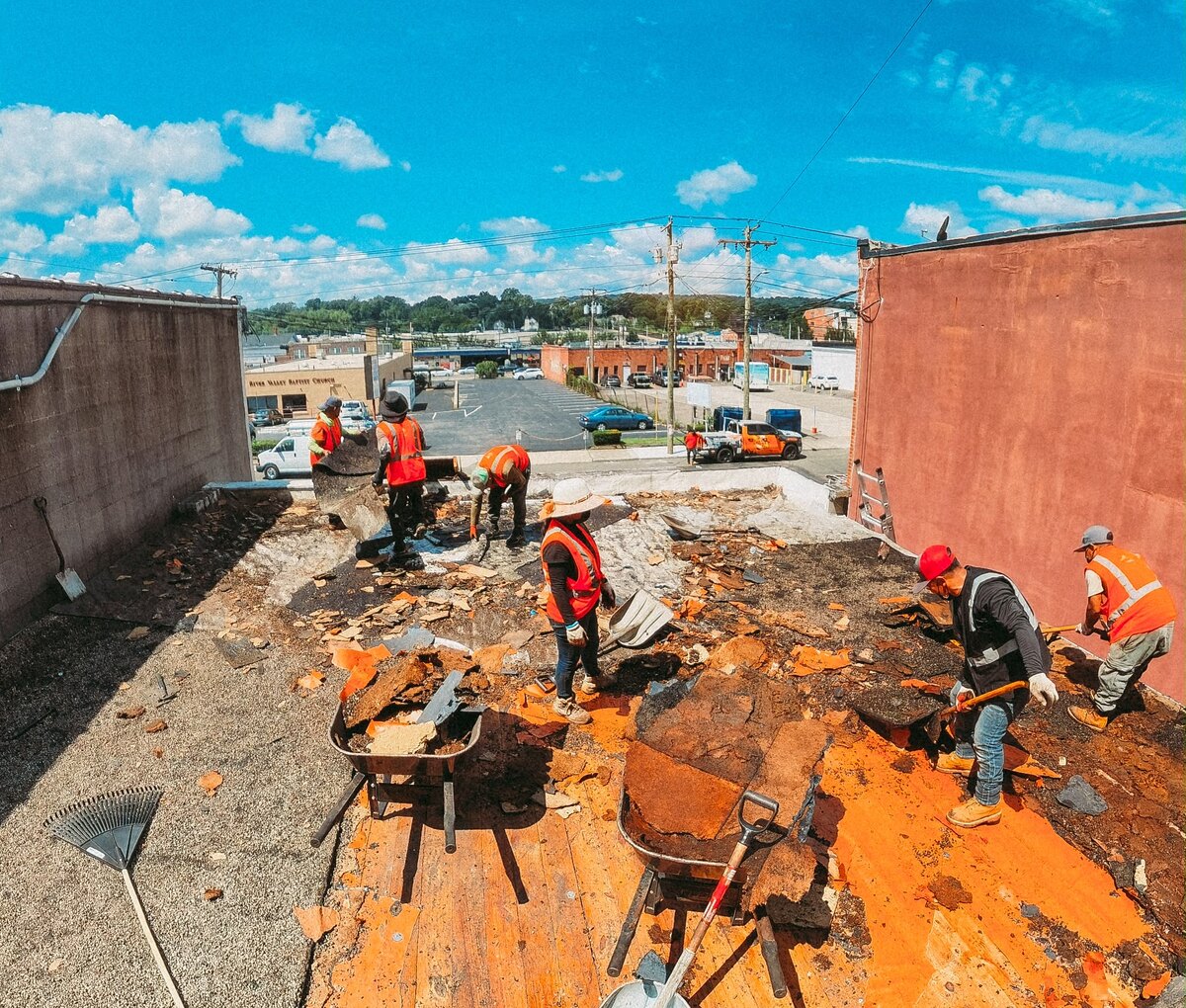 Level One Roofing crew replacing a large roof on a sunny day